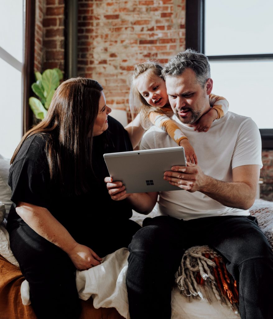 Family sitting looking for a program on the One Stop YQR website